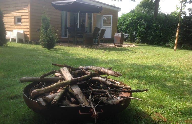 Entspannen Sie sich auf der Terrasse des Ferienhauses in Voorthuizen, Veluwe, Gelderland, umgeben von gruener Natur und ruhiger Umgebung.