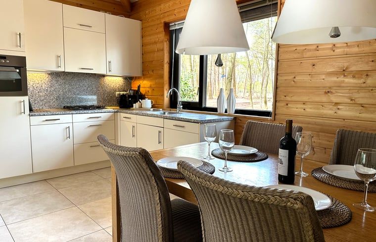 Gemuetliche Kueche im Ferienhaus in Voorthuizen, Veluwe, mit Blick auf die Natur Gelderlands und einem stimmungsvollen Essbereich.