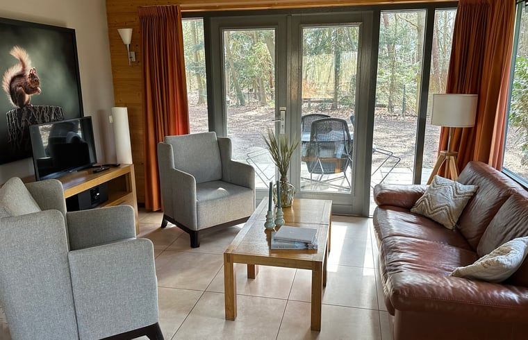 Gemuetliches Wohnzimmer im Ferienhaus in Voorthuizen mit Blick auf die Waelder der Veluwe.