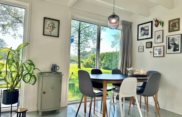 Gemuetliches Esszimmer im Ferienhaus in Voorthuizen, Veluwe, mit Blick auf die gruene Natur und stimmungsvollem Dekor.