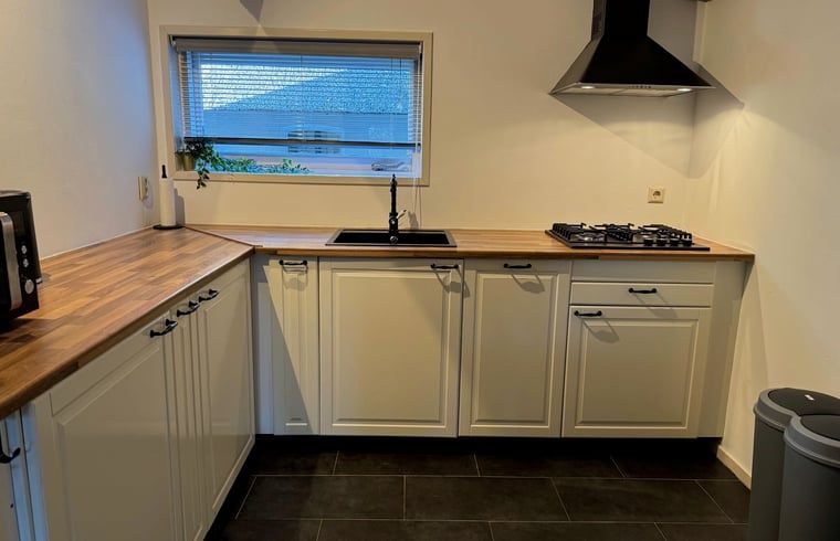 Moderne Kueche mit Holzarbeitsplatte in einem Ferienhaus in Vaassen, Veluwe, Gelderland.