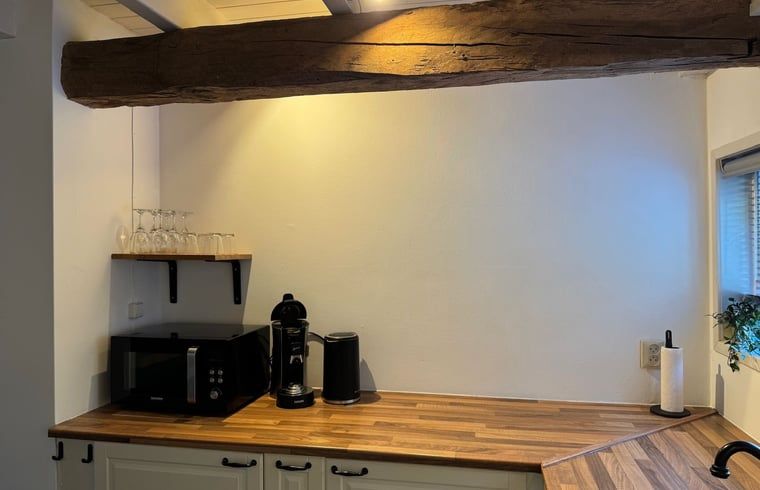 Kuechenzeile mit Geraeten und Holzbalken im Ferienhaus in Vaassen, Veluwe.