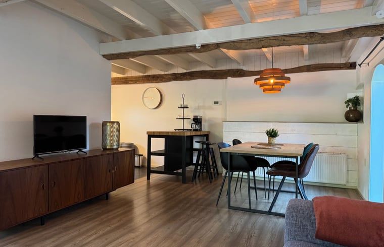 Geraeumiges Esszimmer mit Holztisch im Ferienhaus in Vaassen, Veluwe, Gelderland.