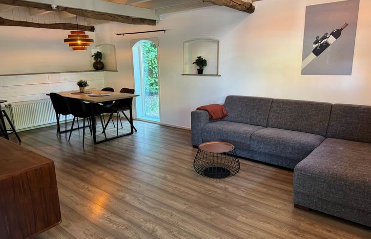 Geraeumiges Wohnzimmer mit Holzboden im Ferienhaus in Vaassen, Veluwe, Gelderland.