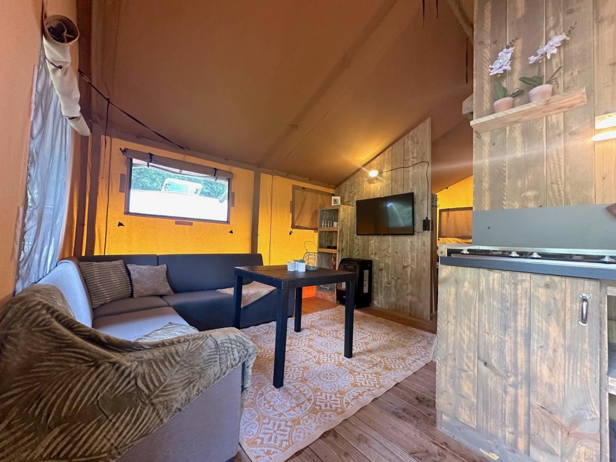 Gezellige binnenruimte van tenthuis Libelle in Hulshorst, Veluwe, met comfortabele zithoek en moderne voorzieningen.