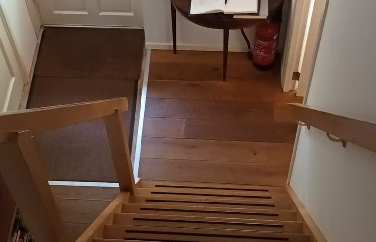 Houten trap in vakantiehuis in Hulshorst, leidt naar knusse zolder, Veluwe, Gelderland.