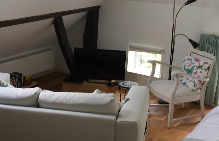 Zithoek op zolder van vakantiehuis in Hulshorst met televisie, Veluwe, Gelderland.