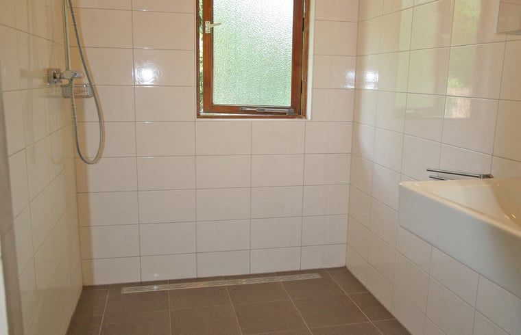 Aussenterrasse von Cottage in Otterlo, Ferienunterkunft in Veluwe, Gelderland mit Holzmoebeln und waldreicher Umgebung.