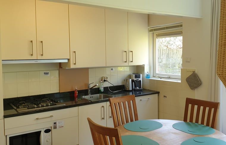 Praktische keuken van Vakantiehuis in Otterlo, Veluwe, met eettafel en veel natuurlijk licht.