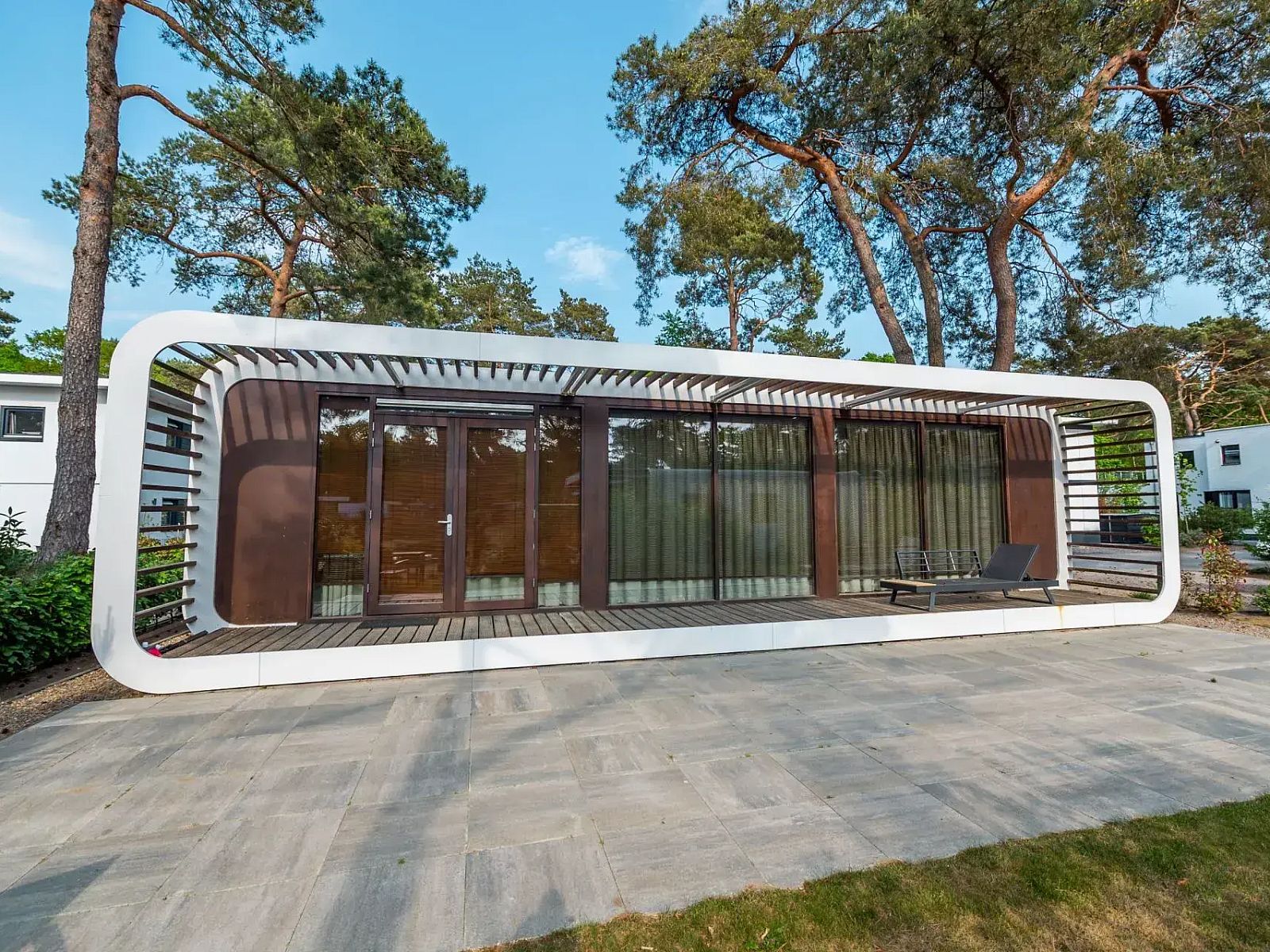 Modus Sauna 2 vakantiehuis in Otterlo, Veluwe, met modern terras omgeven door natuur en hoge bomen in Gelderland.