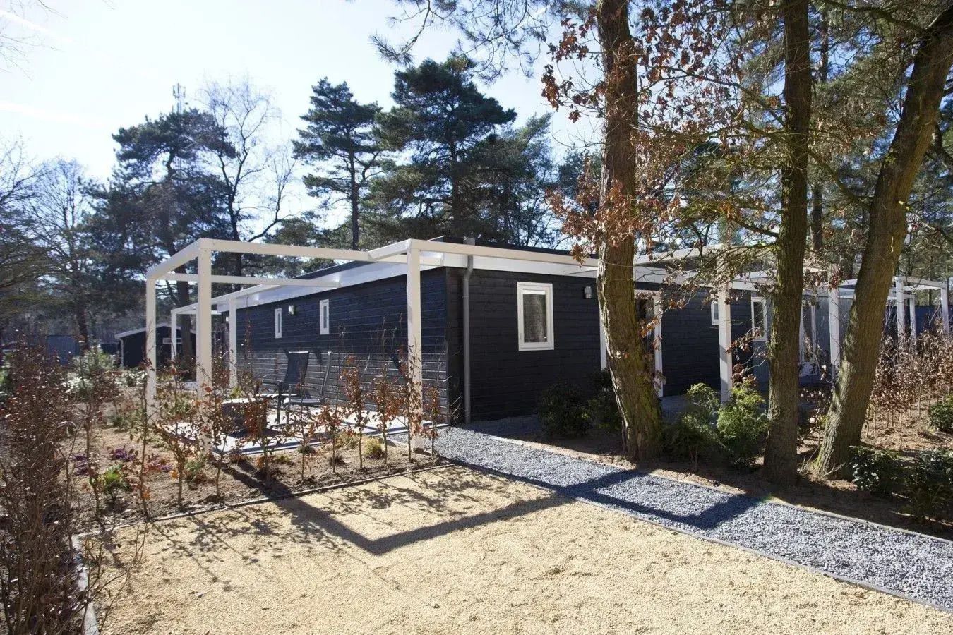 Das Ferienhaus Comfort Room 2 in Otterlo, Veluwe, bietet einen ruhigen Aussenbereich mit einer Terrasse und einer natuerlichen Umgebung in Gelderland.