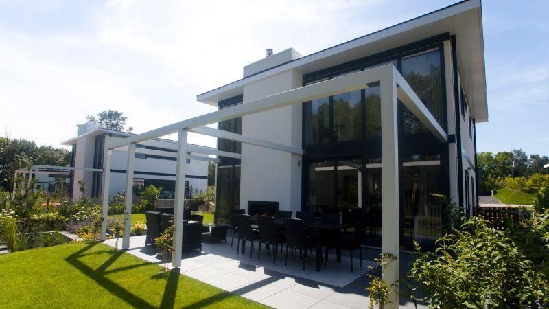 Cube Magnifique 8 vakantiehuis in Otterlo, Veluwe, met ruime veranda en moderne architectuur, omgeven door groene natuur.