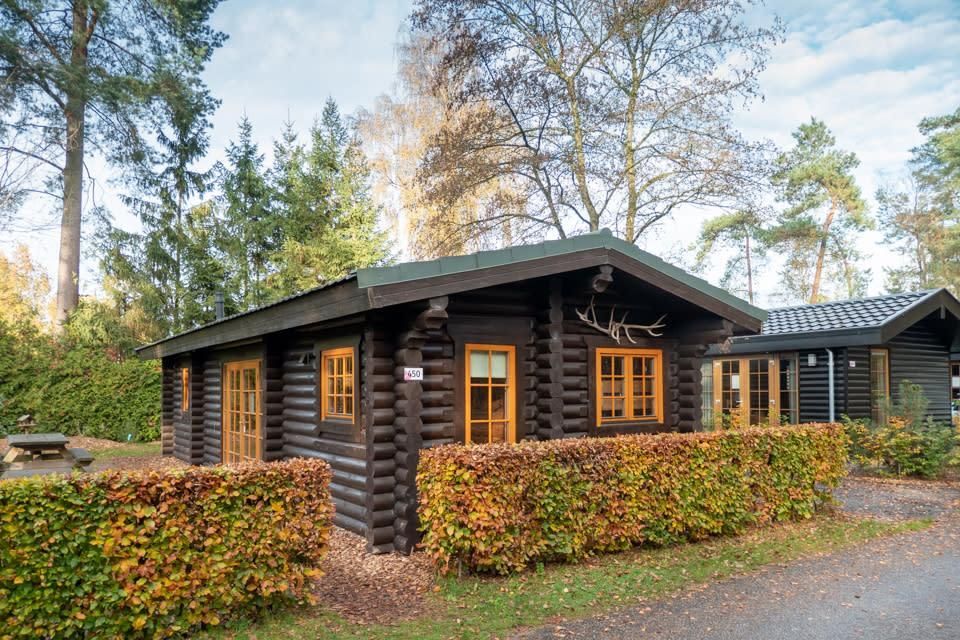 Boekhorst 5 vakantiehuis in Otterlo, Veluwe, omgeven door groen en rustieke houten structuur, ideaal voor een ontspannen verblijf.