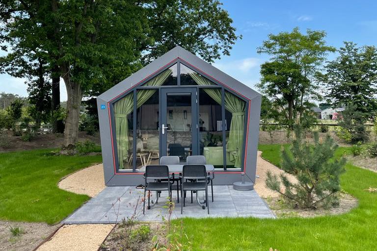 Solo Retreat 4 in Otterlo, Veluwe: modernes Ferienhaus mit Terrasse, umgeben von gruener Natur und ruhiger Umgebung.