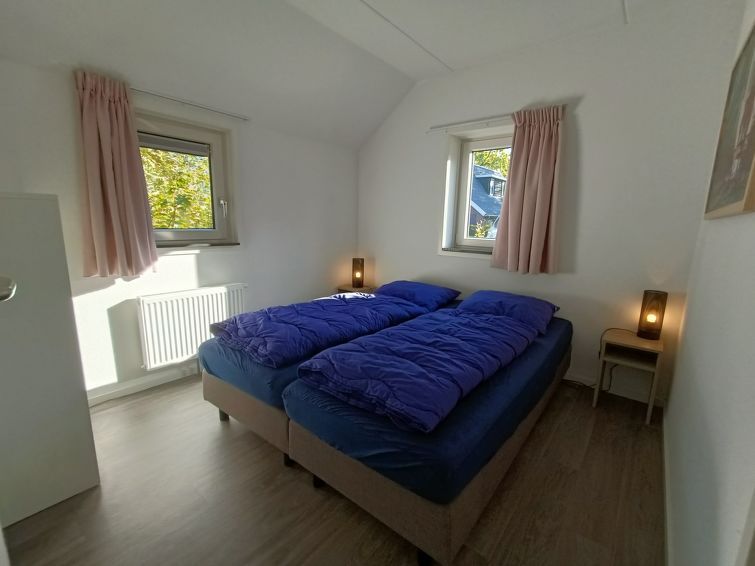 Slaapkamer met tweepersoonsbed in Vakantiehuis Geheim van Otterlo 6 in Otterlo, Veluwe, Gelderland.