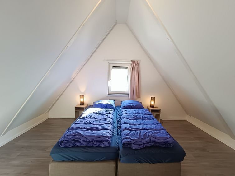 Zolderkamer met comfortabele bedden in Vakantiehuis Geheim van Otterlo 6 in Otterlo, Veluwe, Gelderland.