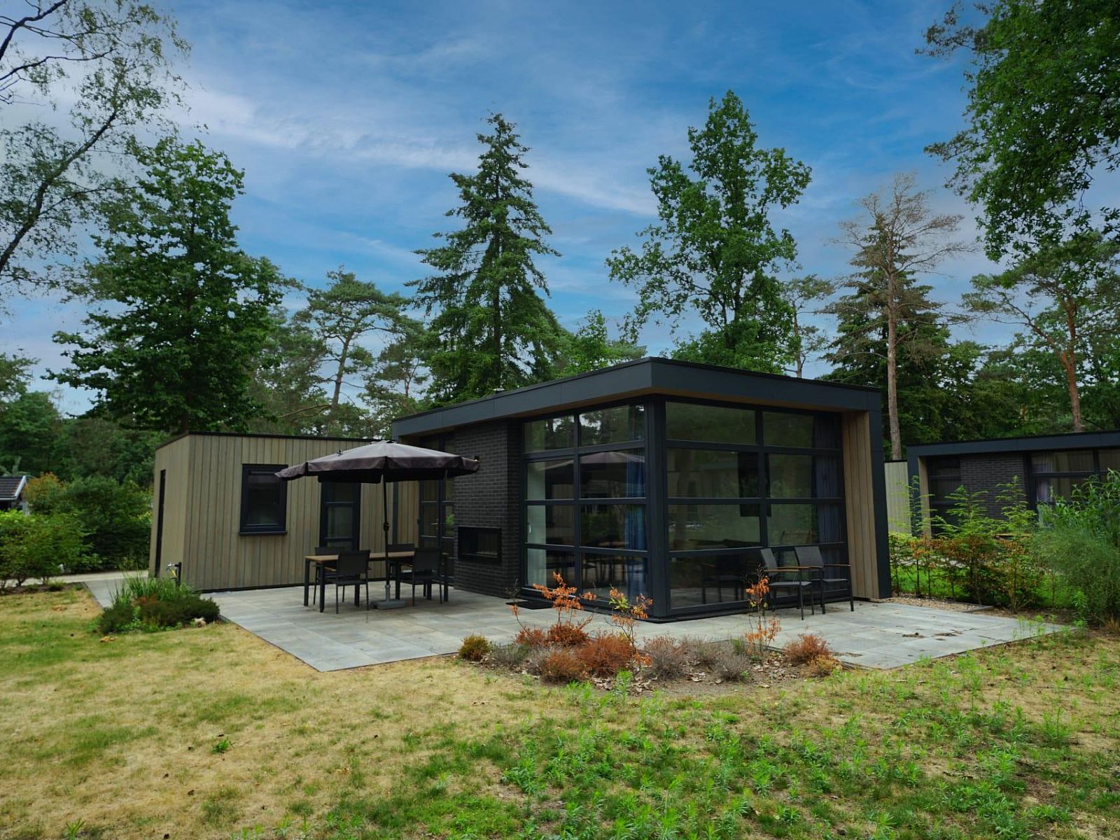 Entspannen Sie sich auf der Terrasse des Ferienhauses L-Cube 4-6 in Otterlo, Veluwe, inmitten der gruenen Natur von Gelderland.