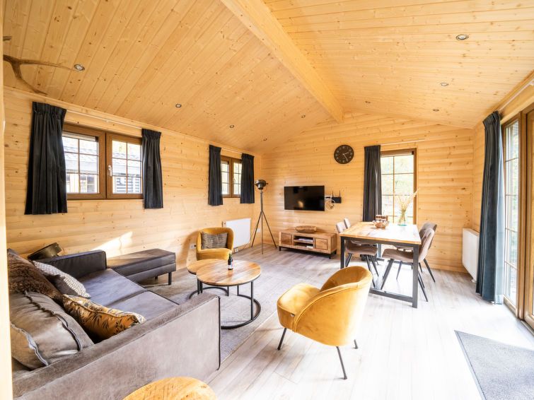 Gezellige woonkamer in Vakantiehuis Boekhorst 5, Otterlo, Veluwe met houten interieur en comfortabele zitruimte.