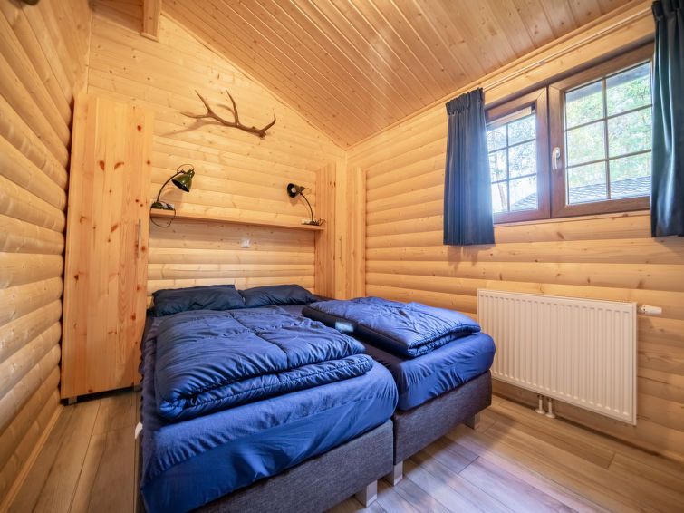 Slaapkamer met twee eenpersoonsbedden in Vakantiehuis Boekhorst 5, Otterlo, Veluwe, met houten muren en raam.