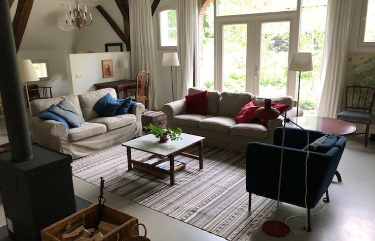 Gezellige woonkamer van Vakantiehuis in Epe, Veluwe, Gelderland, met comfortabele banken en veel natuurlijk licht.