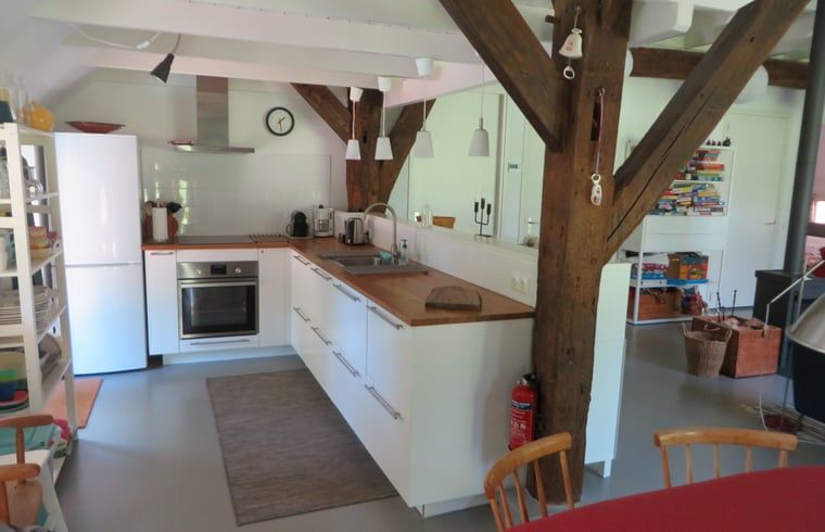 Gezellige keuken in Vakantiehuis in Epe, Veluwe, Gelderland, met moderne apparatuur en rustieke houten balken voor een sfeervol verblijf.