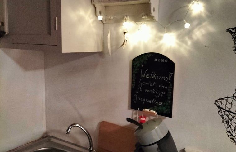 Knusse keukenhoek in Vakantiehuis in Epe, Veluwe, Gelderland met welkomstboodschap en sfeerverlichting.