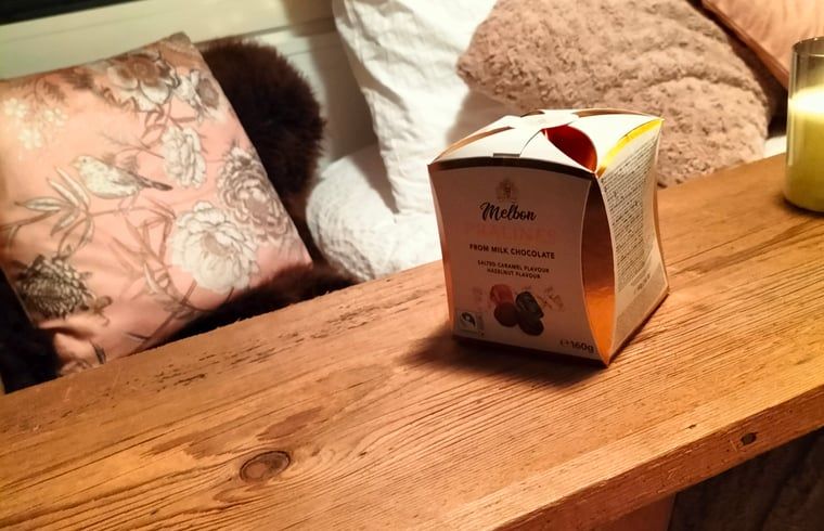 Sfeervolle details in Vakantiehuis in Epe, Veluwe, Gelderland met luxe chocolaatjes en zachte kussens.