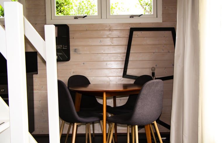 Gemuetlicher Innenbereich des Ferienhauses in Epe, Veluwe, Gelderland, mit Holzwaenden und moderner Essgruppe fuer einen entspannten Aufenthalt.