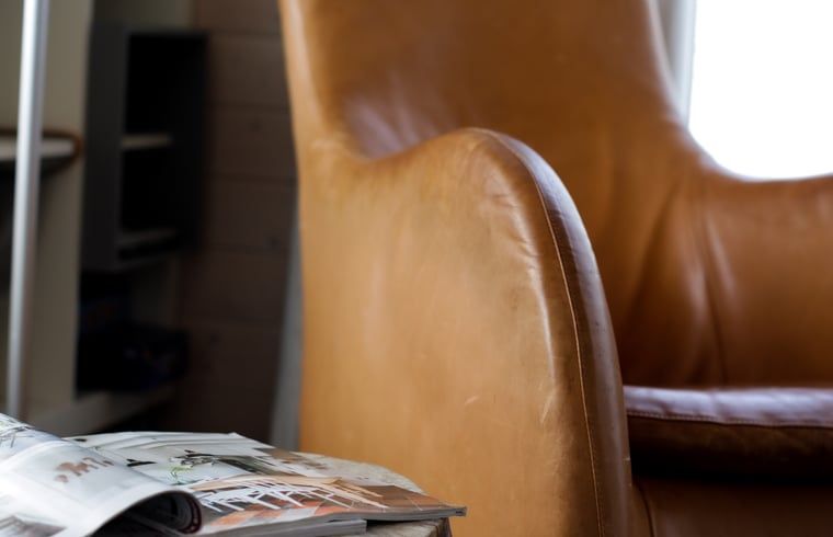 Gemuetliche Leseecke im Ferienhaus in Epe, Veluwe, Gelderland mit bequemem Ledersessel und Zeitschriften zur Entspannung.