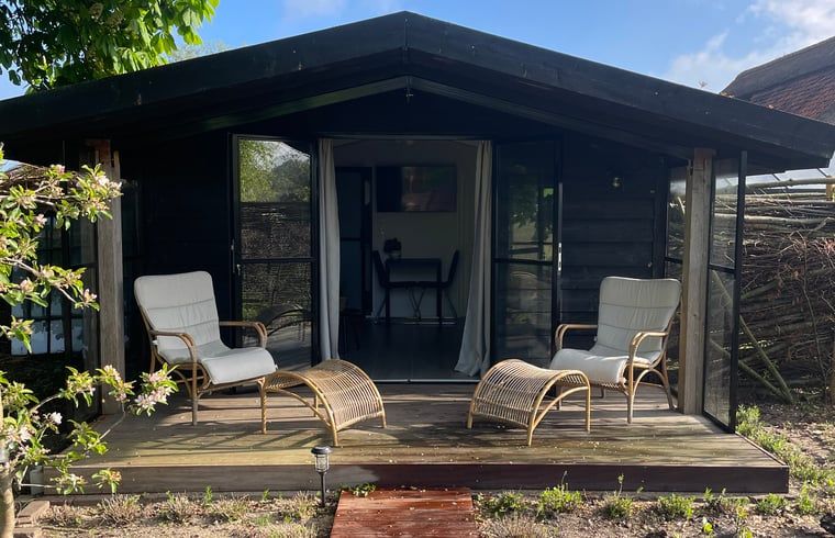 Geniessen Sie die Ruhe und den Frieden auf der Veranda des Ferienhauses in Scherpenzeel Gelderland, einem charmanten Ferienhaus in der Veluwe.