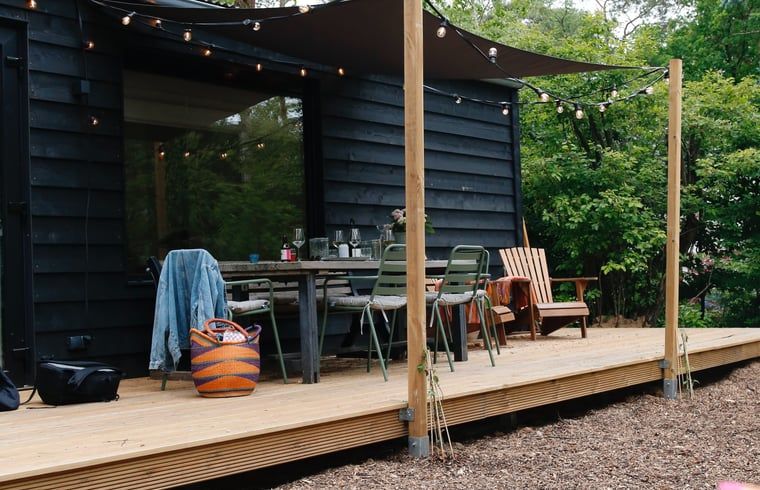 Ruim terras met zitplekken in Huisje in Nunspeet, vakantiehuis op de Veluwe, Gelderland.