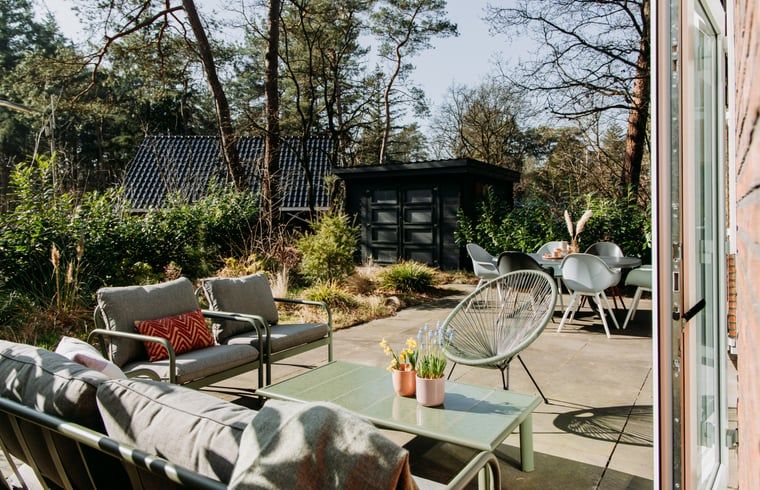 Spacious terrace at cottage in Nunspeet, Veluwe, surrounded by nature and with comfortable seating.