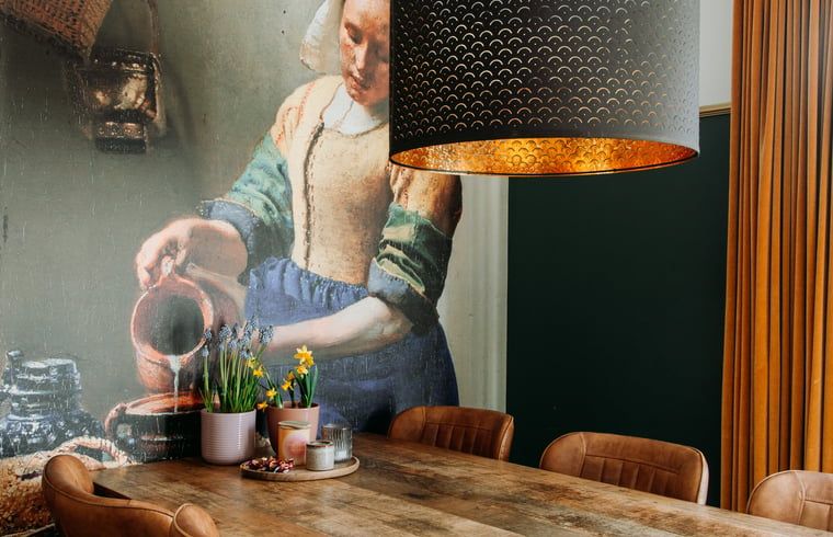 Cozy dining room in Cottage in Nunspeet, Veluwe, with a large table and atmospheric lighting.