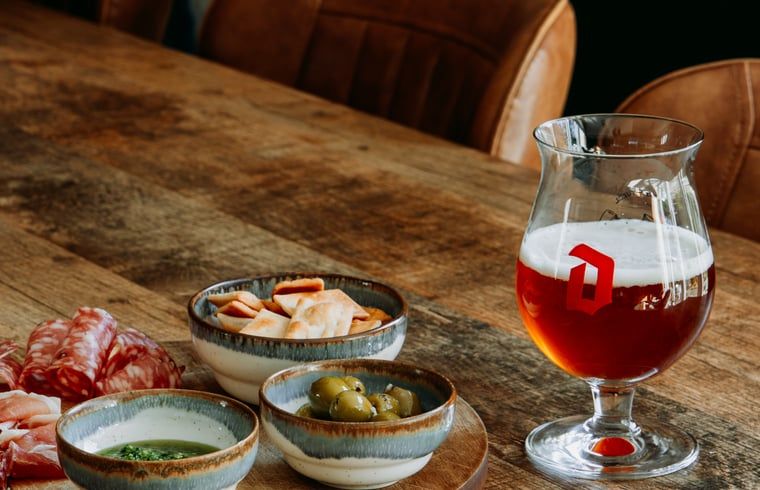 Delicious snacks and a glass of beer at Holiday Home in Nunspeet, Veluwe, perfect for a relaxing evening.