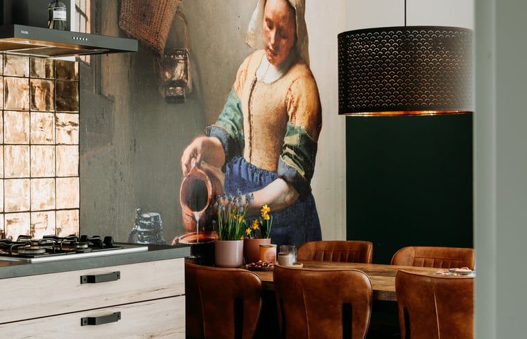 Cozy dining area in Holiday cottage in Nunspeet, Veluwe, with artistic mural and modern lighting.