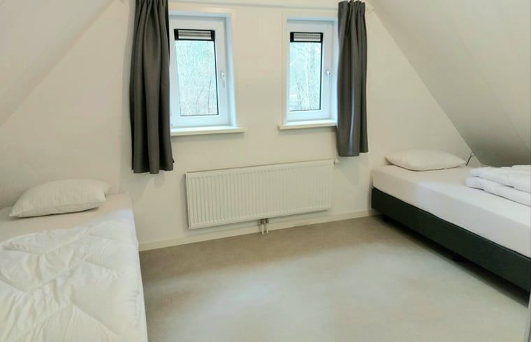 Spacious attic room in cottage in Nunspeet, Veluwe, with two beds for guests in Gelderland.