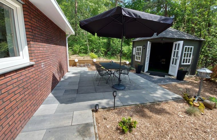 Spacious terrace with parasol at cottage in Nunspeet, Veluwe, perfect for outdoor dining in Gelderland.