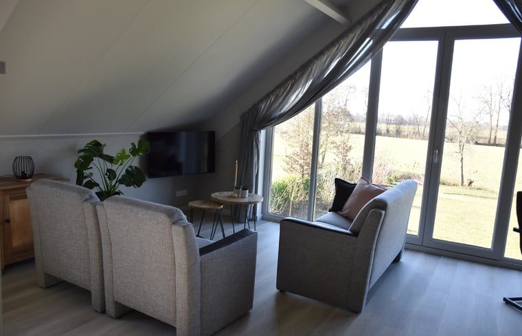 Gemuetliche Sitzecke im Ferienhaus in Lunteren mit Blick auf die Natur in Gelderland.