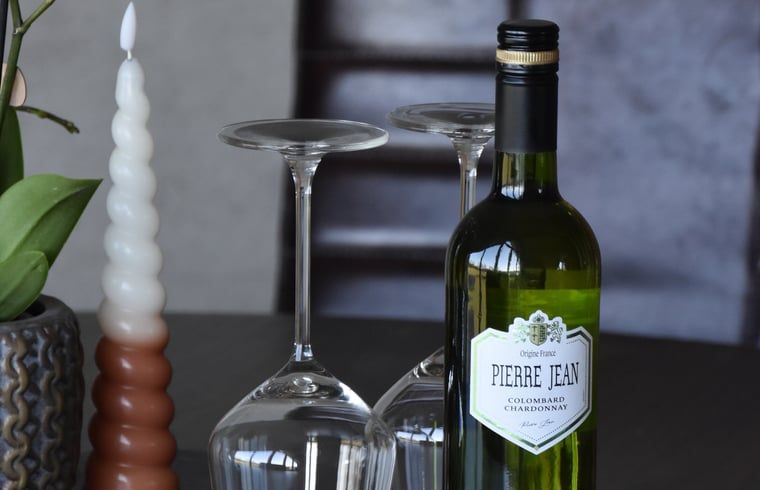 Weinflasche und Glaeser auf dem Tisch im Ferienhaus in Lunteren, Veluwe, Gelderland.