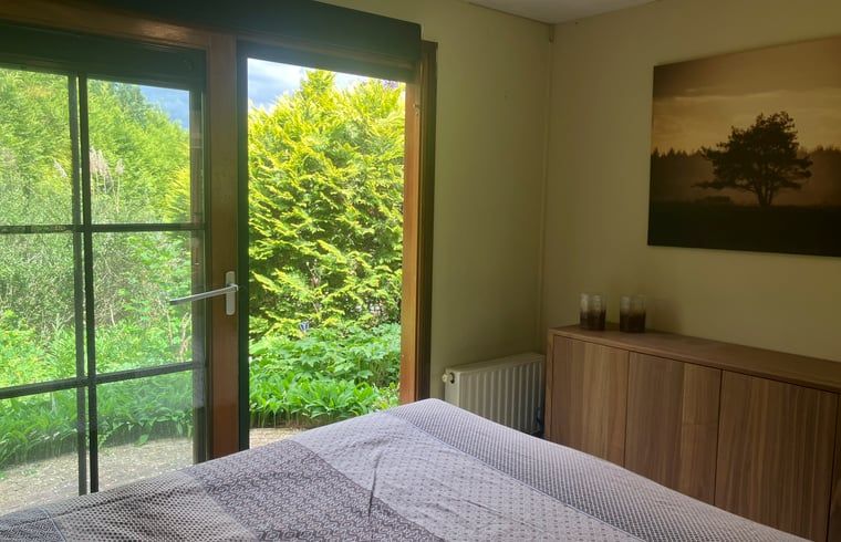 Bedroom in Cottage in Lunteren, Veluwe, with serene nature view.