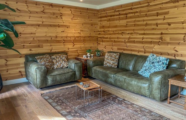 Comfortable sitting area in Cottage in Lunteren, Veluwe, with wooden walls.
