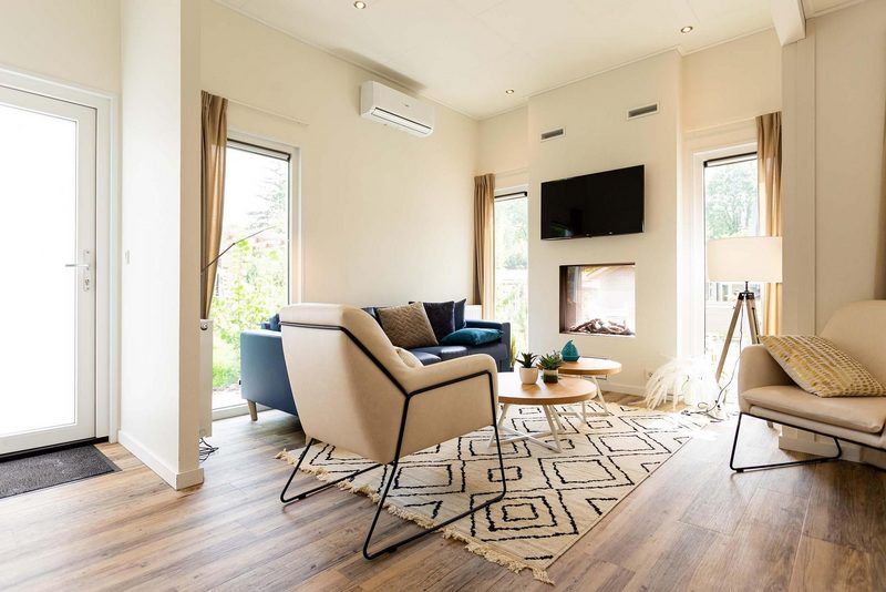 Lichte woonkamer in Lodge Royal 6 personen Wellness in Lunteren, Veluwe, biedt een comfortabele plek om te ontspannen.
