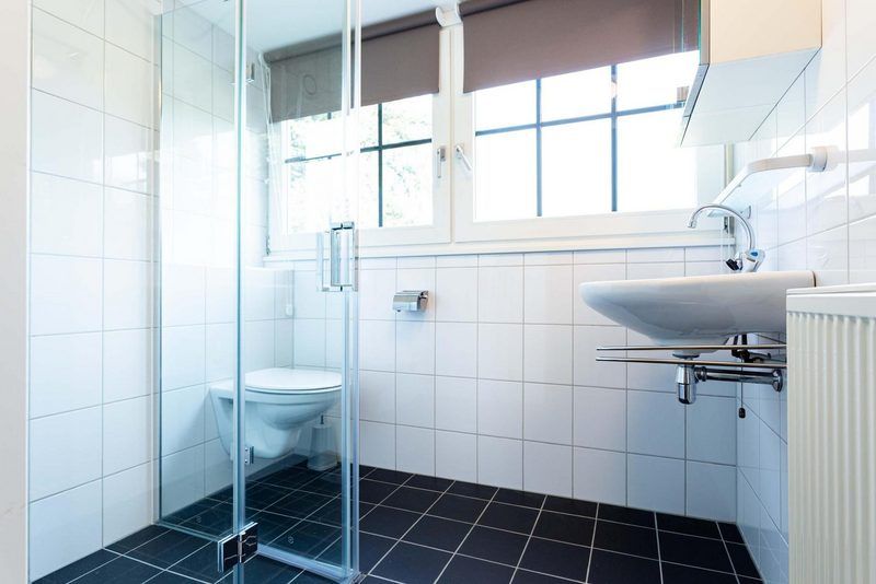 Modernes Badezimmer in Boshoeve 10 Personen Wellness Spa Ferienhaus Lunteren, Veluwe mit Glasdusche und Fenster.