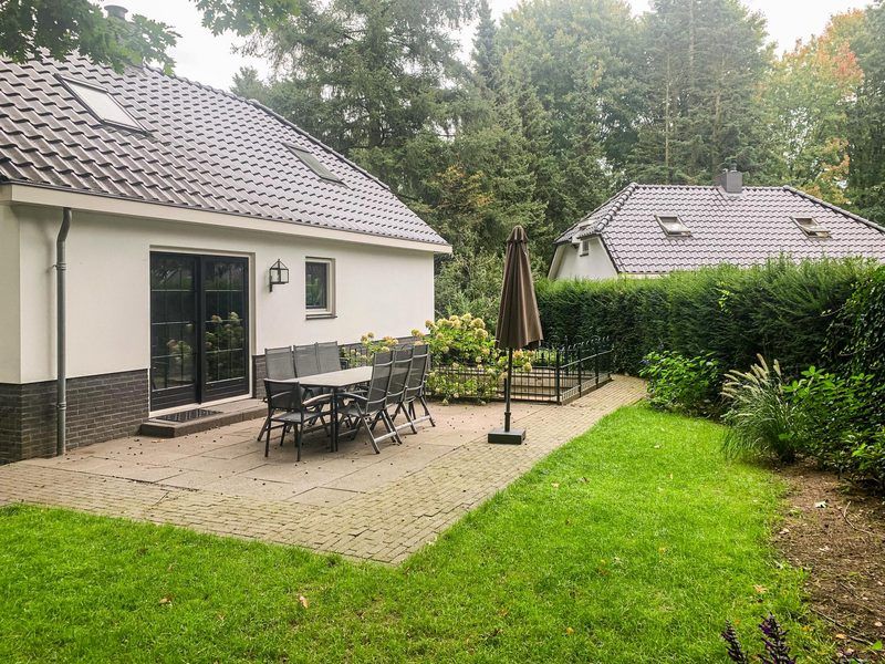 Terrasse am Boshoeve 10 Personen Wellness Spa Ferienhaus Lunteren, Veluwe mit Gartenmoebeln und gruener Umgebung.
