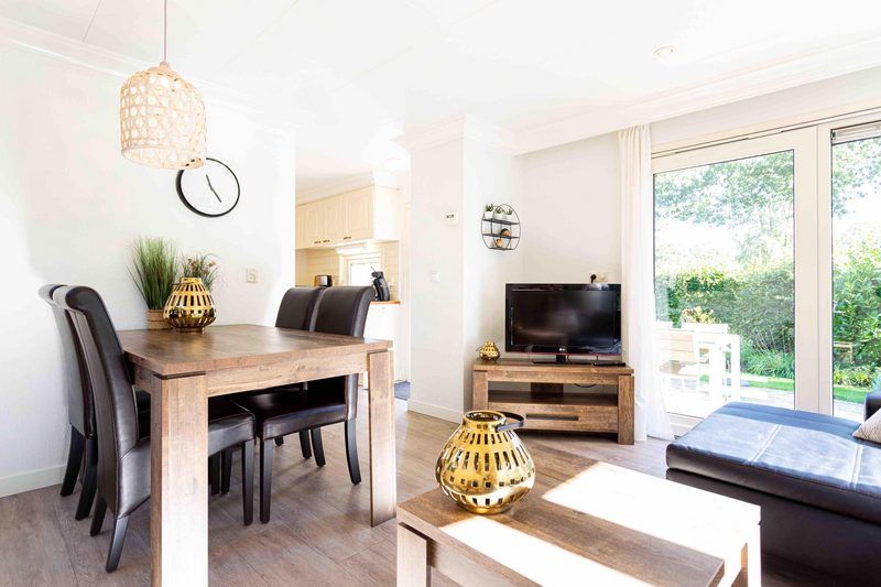 Geraeumiges Wohnzimmer im Ferienhaus fuer 4 Personen, Lunteren, Veluwe, Gelderland mit Ess- und Sitzecke.