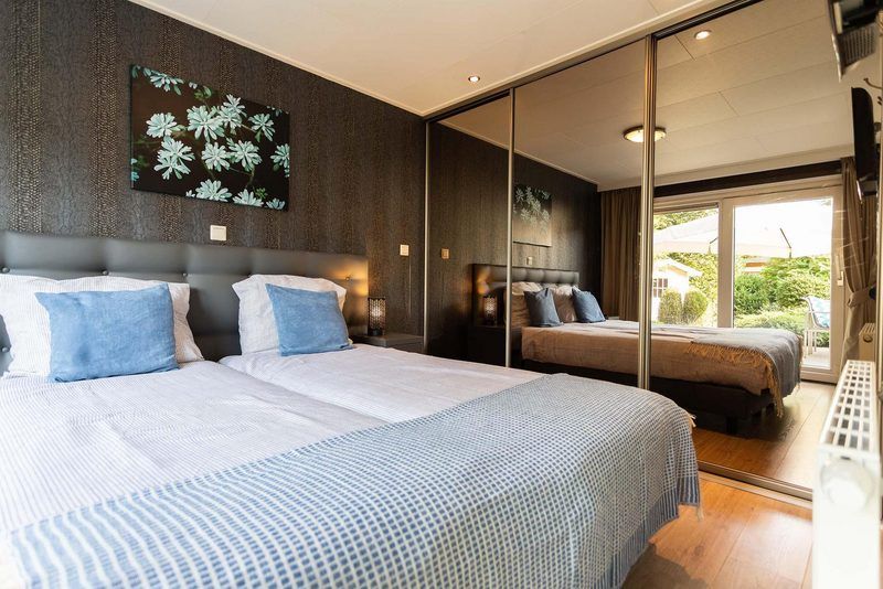 Slaapkamer in Holiday home 5 personen Wellness, Lunteren, met uitzicht op tuin, Veluwe.