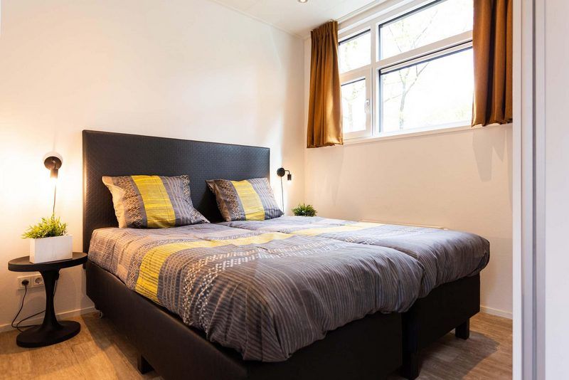 Gemuetliches Schlafzimmer in Modul Spezial 6 Personen Ferienhaus in Lunteren, Veluwe, mit Doppelbett.