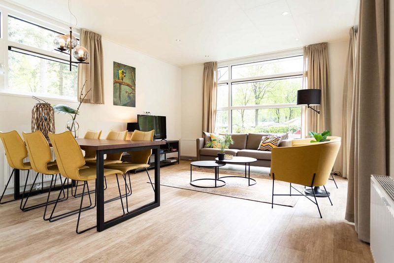 Stilvolles Wohnzimmer in Modul Spezial Ferienhaus fuer 6 Personen, Lunteren, Veluwe, mit grossen Fenstern.