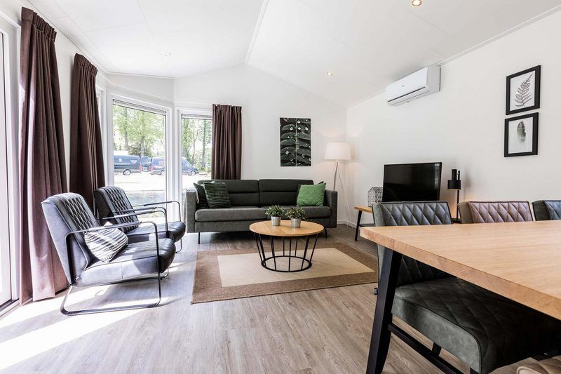 Gezellige woonkamer in Ferox 5 personen Wellness vakantiehuis, Lunteren, Veluwe, met zitgedeelte en tv.