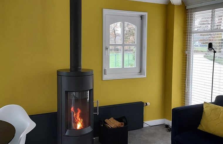 Moderner Holzofen im Wohnzimmer des Ferienhauses in Heerde, Gelderland.